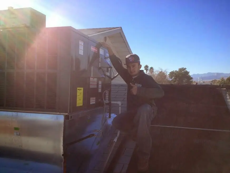 HVAC technician performing HVAC Inspection on a rooftop unit in Galloway
